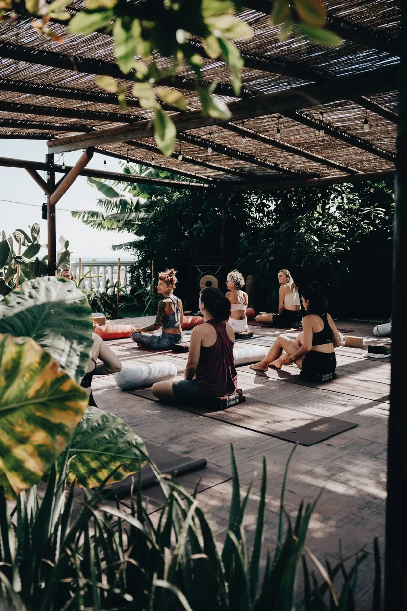 Yoga-Session unter einer Holzpergola mit Blick ins Grüne